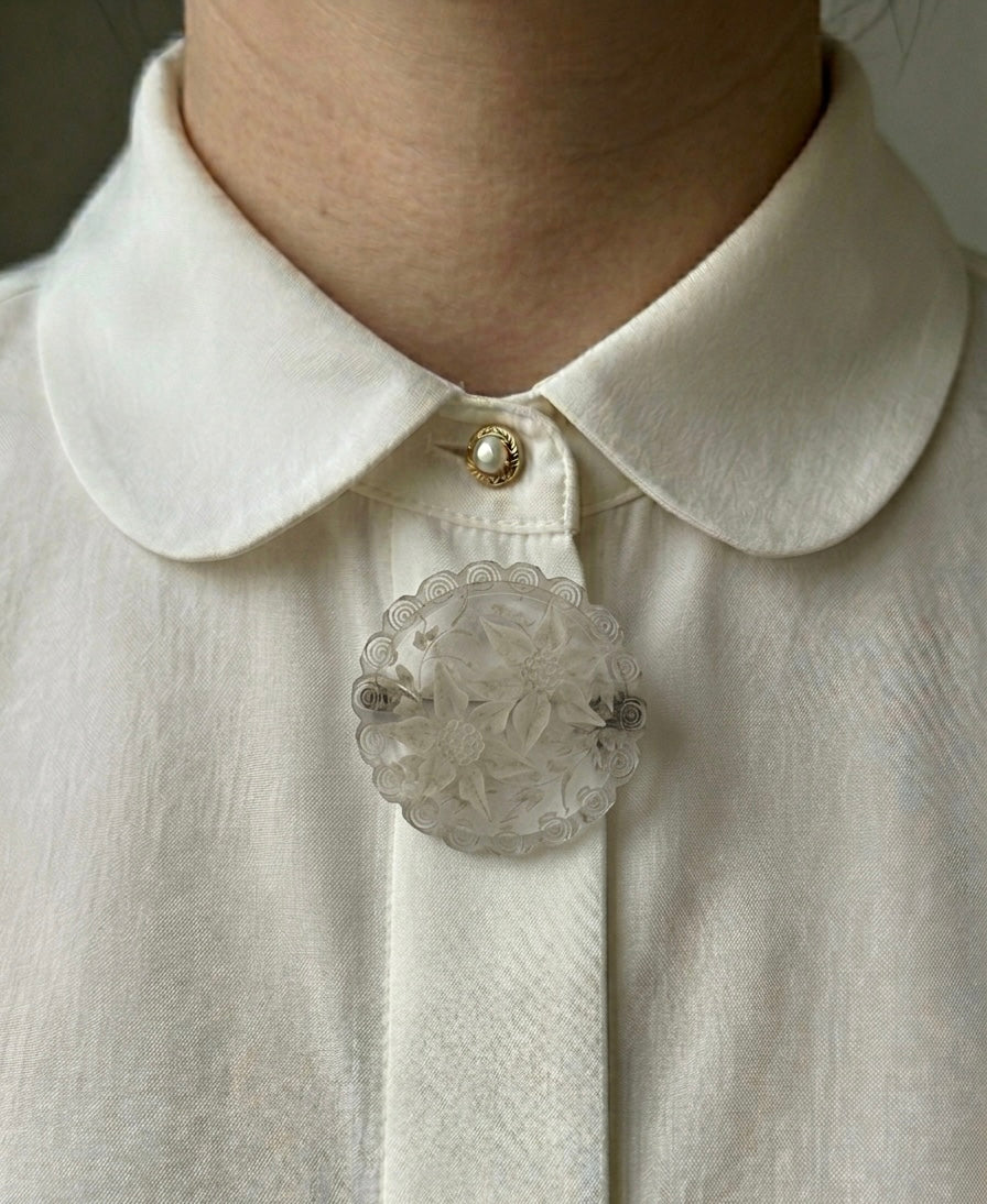 Broche ronde transparente avec fleurs blanches