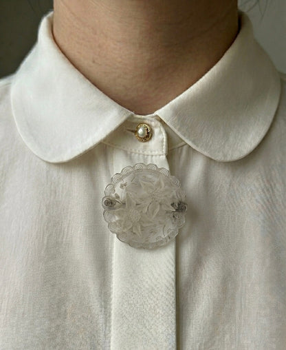 Broche ronde transparente avec fleurs blanches